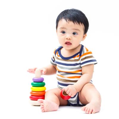 Baby sitting on floor with ring toy