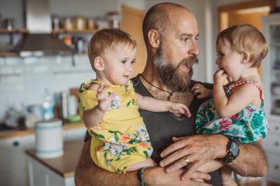 dad holding twins in a kitchen