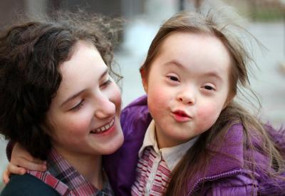 Girl holding child with Downs Syndrome