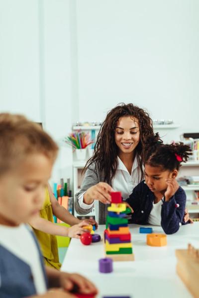 child care provider playing blocks with child