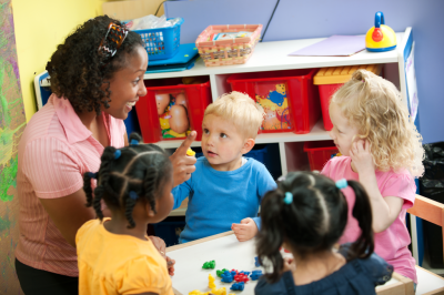child care provider at a table with children