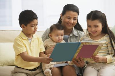 Hispanic mom reading to three children.