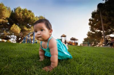 Native American baby girl/toddler crawling on grass