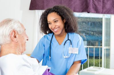 a nurse talking to an elderly patient 