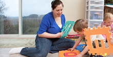 child care provider playing iwth two children